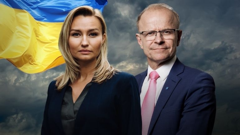 Ebba Busch och Mikael Oscarsson står bredvid varandra med Ukrainas flagga i bakgrunden